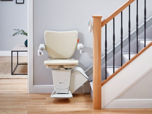 Moderner Sitztreppenlift auf einer geraden Treppe mit sauberem Traktionsantrieb ohne Zahnstange.